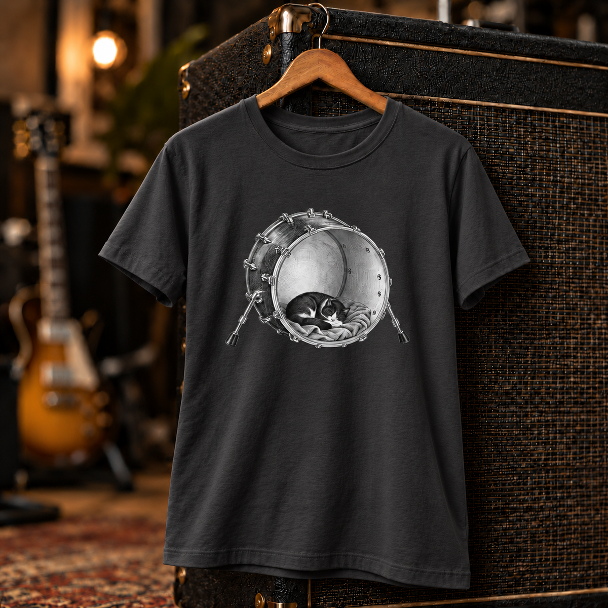 Kick Nap unisex tee styled on a studio set – cat asleep inside a kick drum